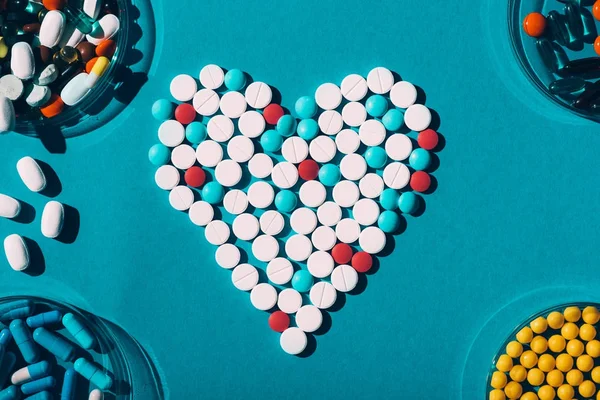 Pílulas coloridas no símbolo do coração — Fotografia de Stock