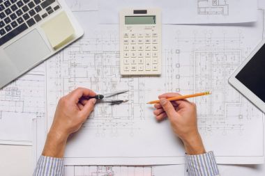 architect working with blueprints and calculator clipart