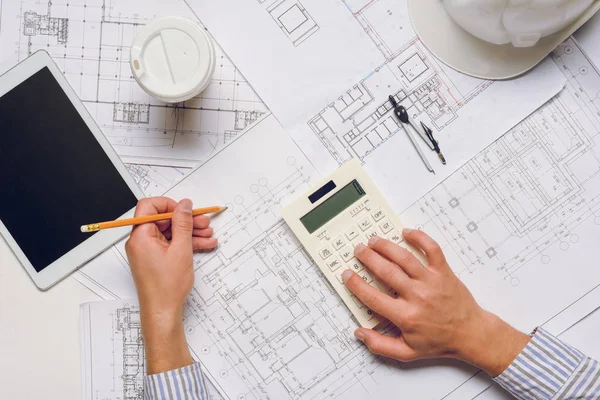 Architect working with blueprints and calculator — Stock Photo, Image