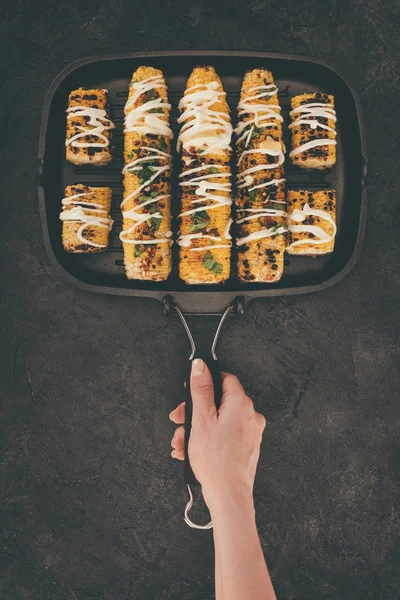 Woman holding grill pan with corn — Free Stock Photo