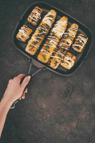 Woman holding grill pan with corn — Free Stock Photo