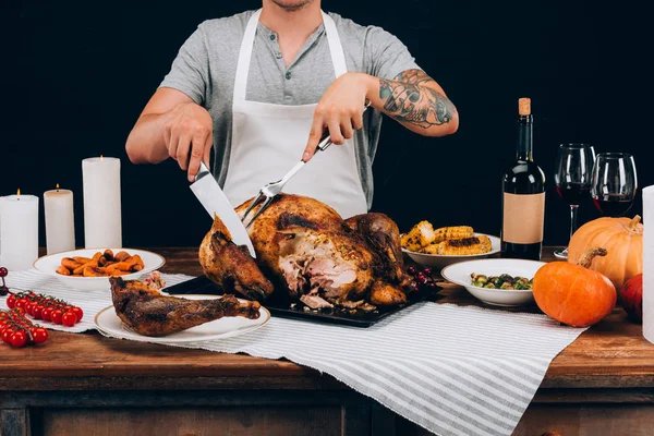 Man cutting turkey on thanksgiving day — Stock Photo, Image