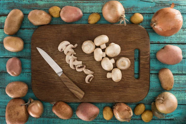 Cut and whole mushrooms on wooden board — Stock Photo, Image