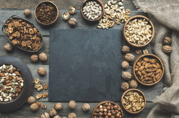 Various nuts and slate board — Stock Photo, Image