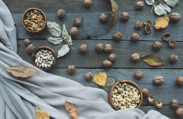 Frutos secos surtidos y hojas de otoño —  Fotos de Stock