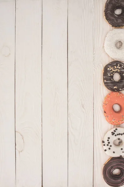 Donuts on wooden table top — Stock Photo, Image