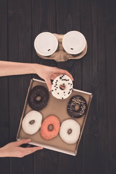 Doos met donuts in handen — Stockfoto