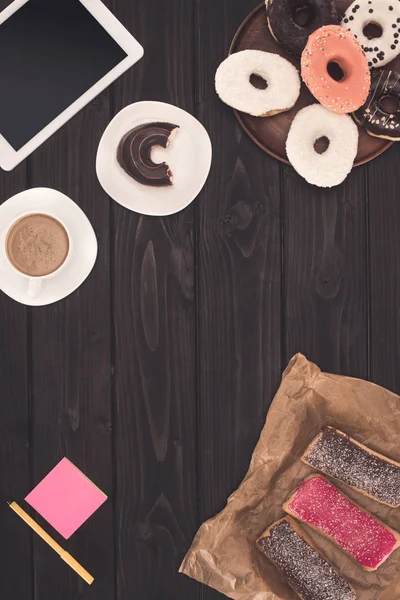 Rosquillas, café y tabletas digitales — Foto de Stock