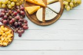 Různé typy sýrů a hrozny