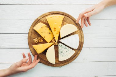 female hands and arranged types of cheese clipart