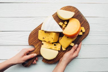 el ve ahşap tahta üzerinde çeşitli peynir