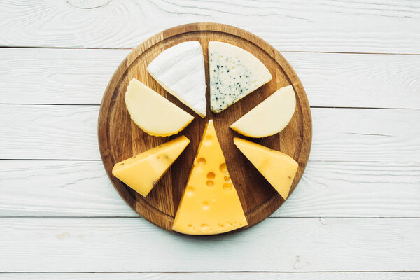 assorted types of cheese on cutting board