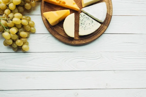 Various types of cheese and grapes — Stock Photo, Image