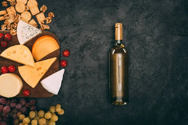 チーズの盛り合わせとワインのボトル — ストック写真
