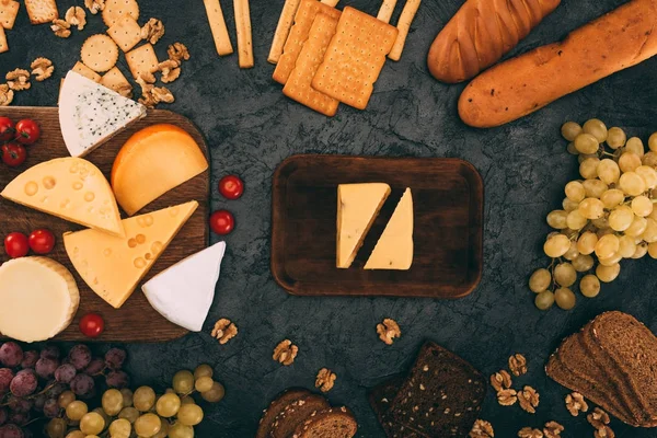 Various cheese types, bread and grapes — Stock Photo, Image