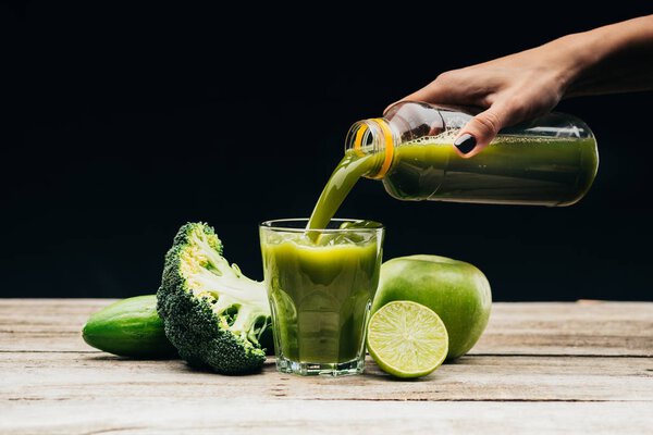 woman pouring fresh juice into glass