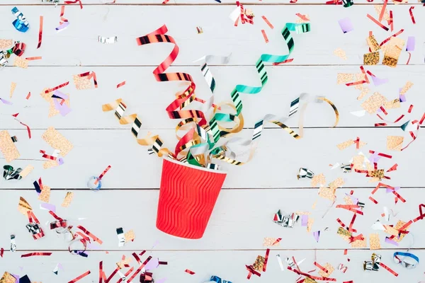 Confetti spilling out of paper cup — Stock Photo, Image