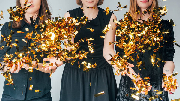 women throwing golden confetti
