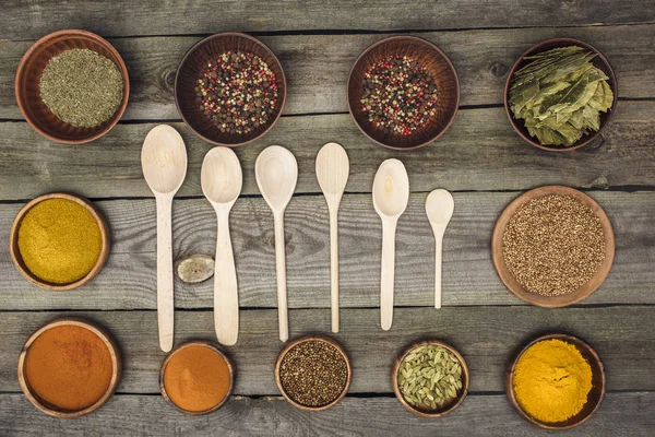 Wooden spoons among bowls with spices — Free Stock Photo