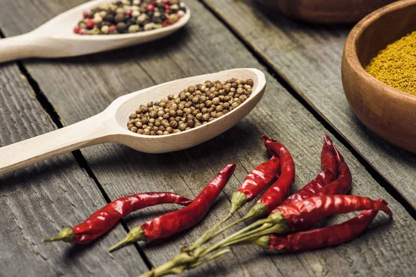 Pimentos e colheres de pimenta com especiarias — Fotografia de Stock