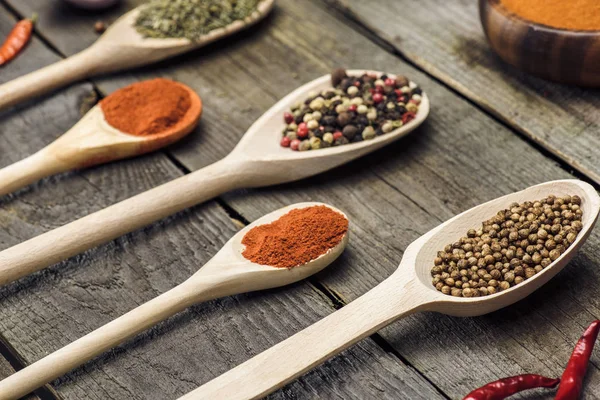 Wooden ladles with different spices — Stock Photo, Image