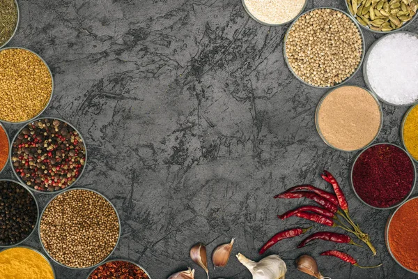 Kryddor i skålar med chilipeppar och vitlök — Stockfoto