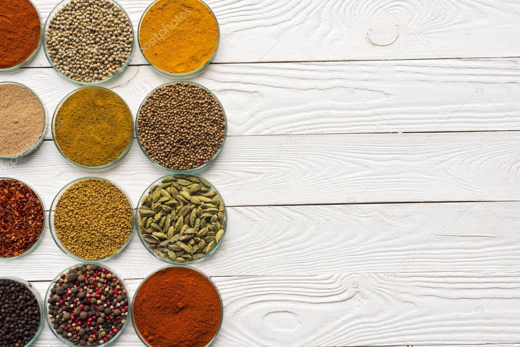 spices in glass bowls on white surface