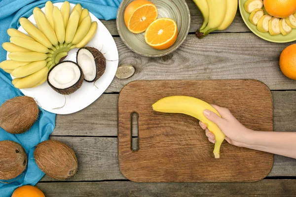 Hand holding banana — Free Stock Photo