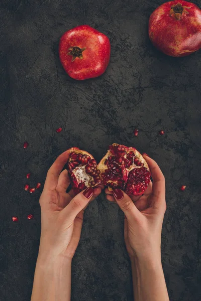 Frau hält Granatapfelstücke in der Hand — Stockfoto