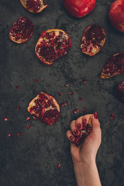 Woman holding pomegranate piece — Stock Photo, Image