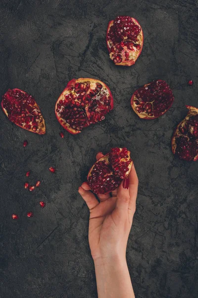 Woman holding pomegranate piece in hand — Stock Photo, Image