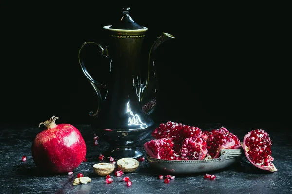 Zwarte theepot en granaatappels — Stockfoto