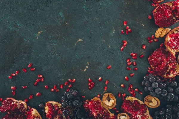 Pomegranates with grapes and walnuts — Stock Photo, Image