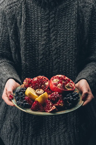 Γυναίκα που κρατά το πιάτο με φρούτα στα χέρια — Φωτογραφία Αρχείου