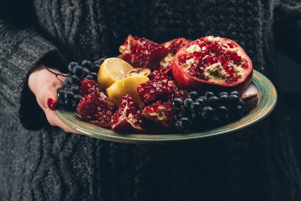 Vrouw met bord met fruit in de hand — Stockfoto