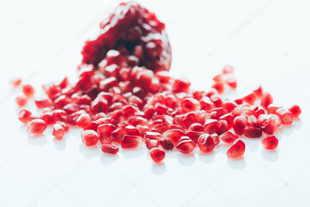 Ripe pomegranate with scattered seeds