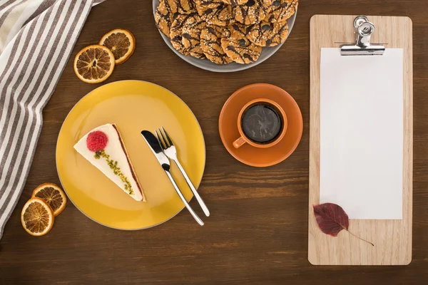 Sheet of paper on clipboard and dessert — Stock Photo, Image