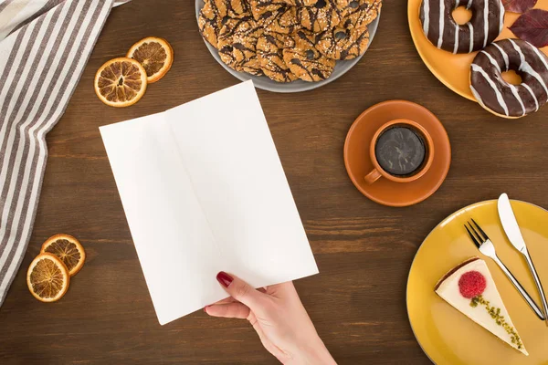 Mano con menú en blanco y galletas — Foto de Stock