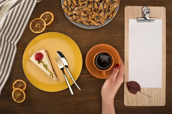 Hand with coffee and pastries — Stock Photo, Image