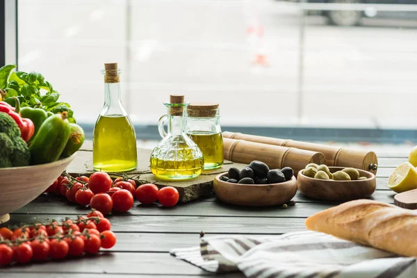 Olive oil bottles with vegetables — Stock Photo, Image