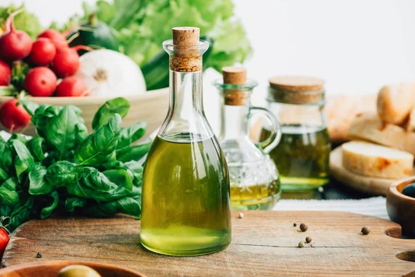 Olive oil bottles with vegetables — Stock Photo, Image