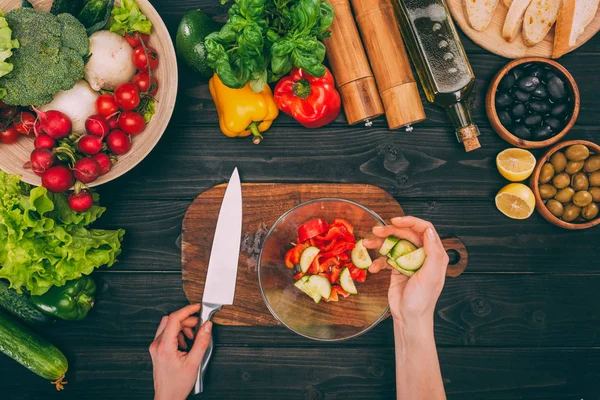 Hands with knife and vegetables — Stock Photo, Image