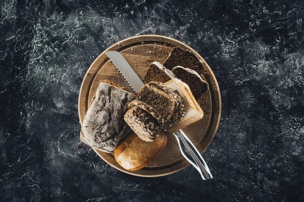 Brood en mes op snijplank — Stockfoto
