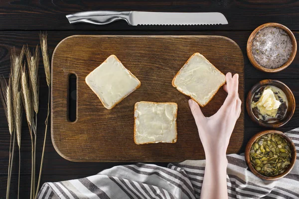 Rostat bröd med smör och mänsklig hand — Stockfoto