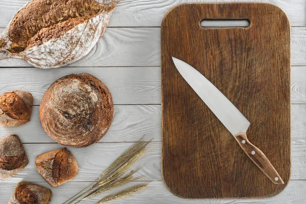 Bread and cutting board with knife — Stock Photo, Image