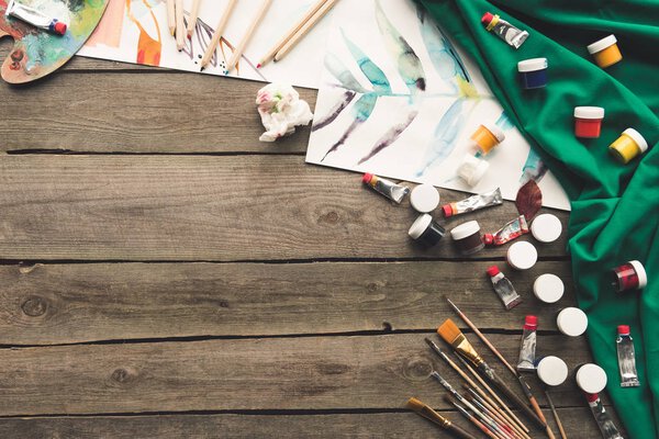 разбросаны различные краски и эскизы
