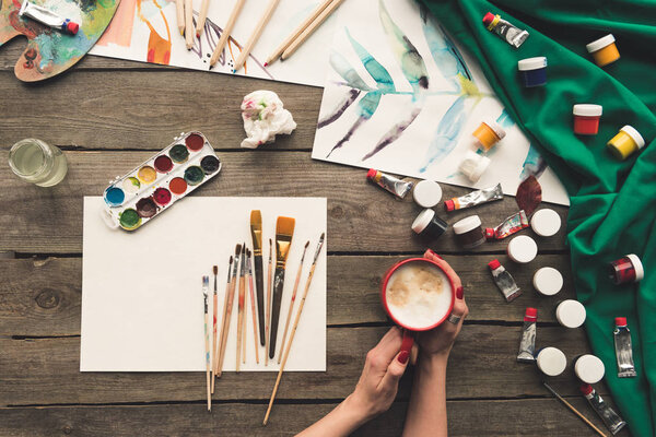 artist drinking coffee at working place 