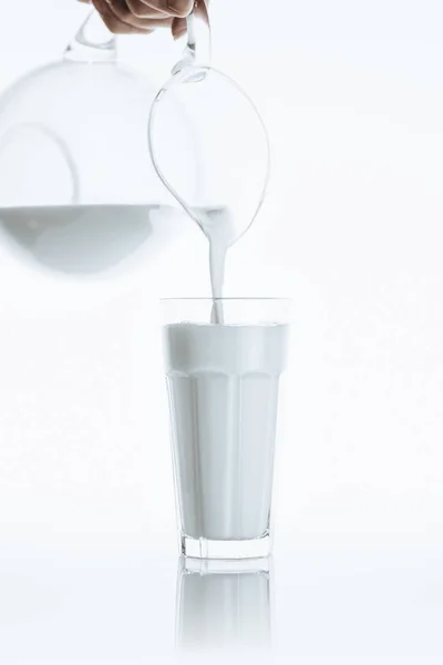 Pouring milk from jar into glass — Stock Photo, Image