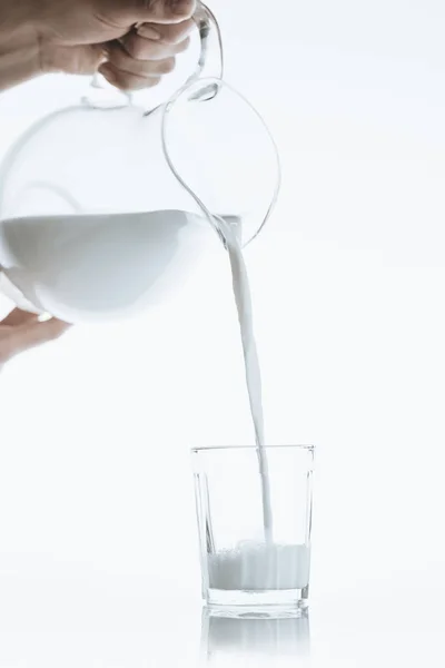 Person pouring milk from jar — Stock Photo, Image