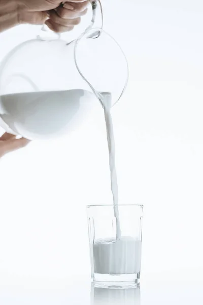 Person pouring milk into glass — Stock Photo, Image